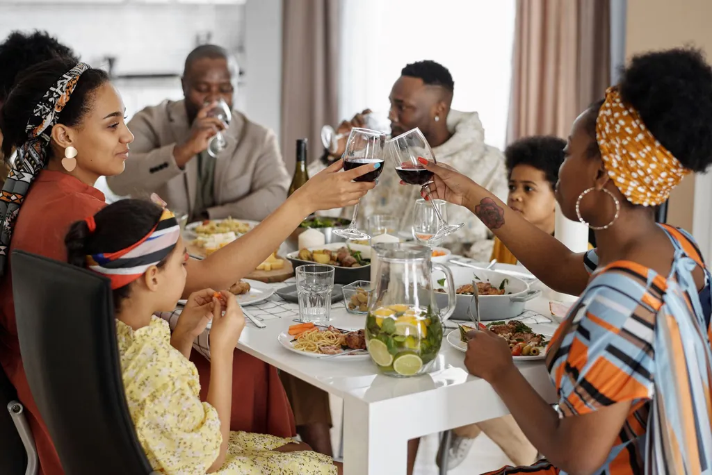 Familie en vrienden van verschillende generaties proosten samen aan een gedekte tafel